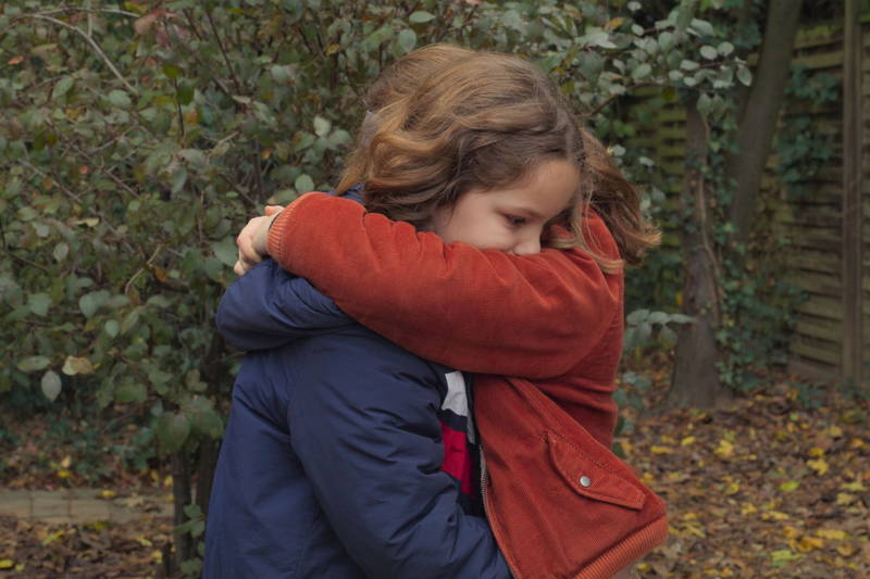 真っ赤に染まった秋の森　一緒に作った小屋を眺める2人の少女　「秘密の森の、その向こう」場面写真