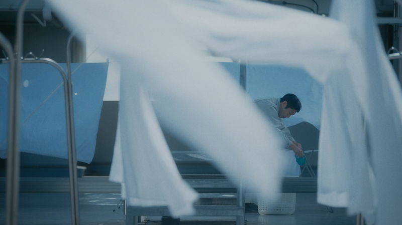 香川照之　不安にも必死にも見える表情で窓ガラスをホースで清掃する姿　「災 劇場版」場面写真