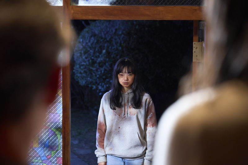 古川琴音　服や顔には血がつき、うつろな表情で家族を見つめる姿　「みなに幸あれ」場面写真