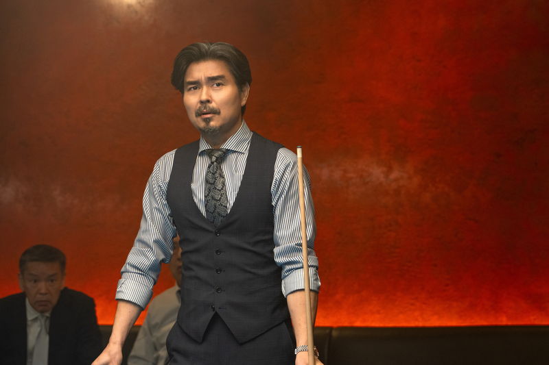 不安げに電話する内野聖陽　するどく相手をうかがう岡田将生　「アングリースクワッド」場面写真