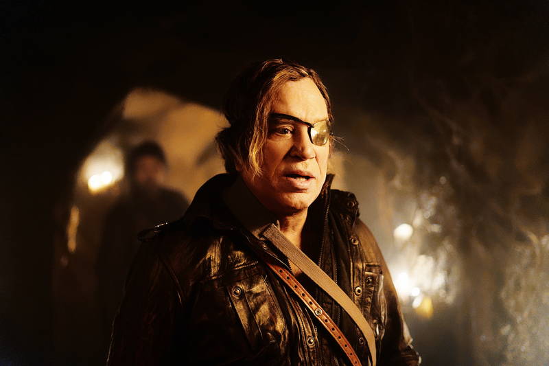 不気味な笑みを見せるミッキー・ローク　白骨死体を見つける兵士　「ウォーハント 魔界戦線」場面写真