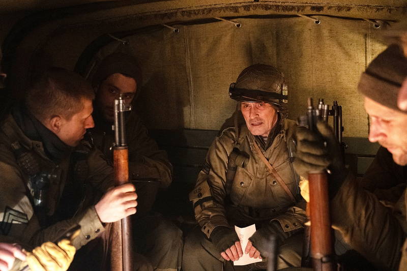 不気味な笑みを見せるミッキー・ローク　白骨死体を見つける兵士　「ウォーハント 魔界戦線」場面写真